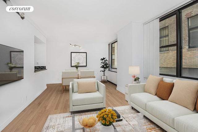 living area with hardwood / wood-style floors, visible vents, and baseboards