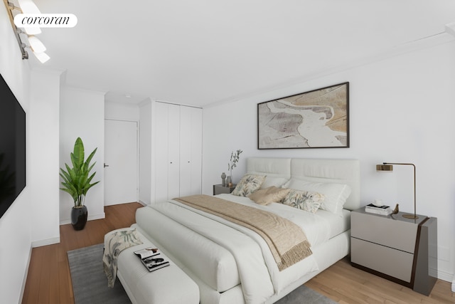 bedroom with a closet, wood finished floors, and visible vents