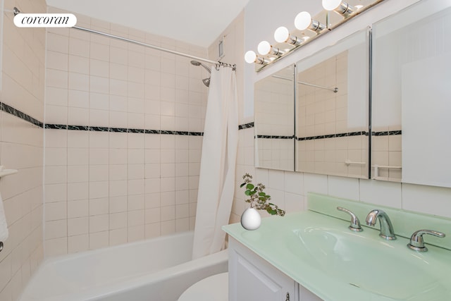 bathroom featuring toilet, shower / tub combo, vanity, tile walls, and backsplash