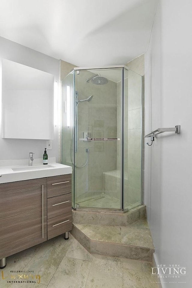 bathroom with a shower stall and vanity