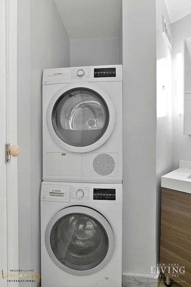 laundry room featuring stacked washer / drying machine, laundry area, and visible vents