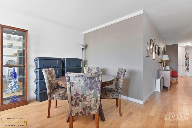 330 E 38th St Unit 24A, New York City, NY 10016 - dining space featuring wood finished floors, ornamental molding, and baseboards