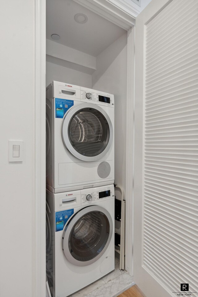 washroom with stacked washer and dryer and laundry area