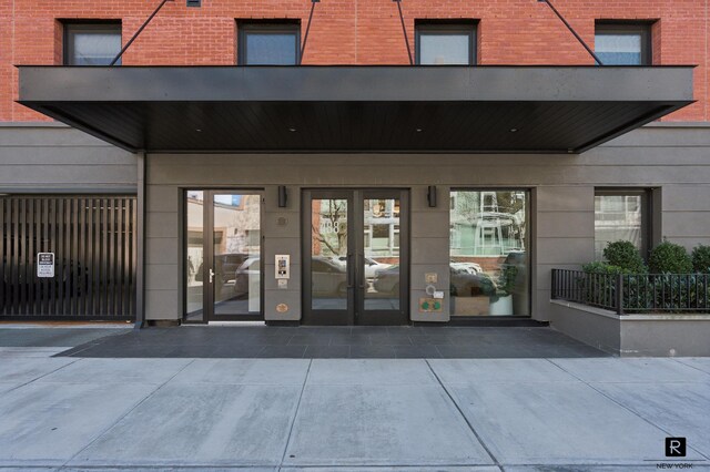 view of exterior entry with brick siding and french doors