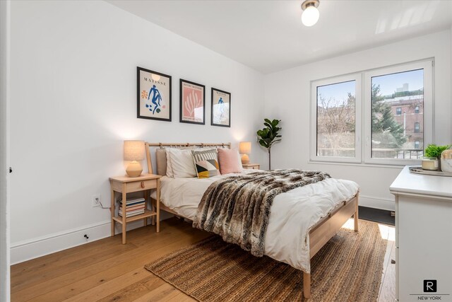 bedroom featuring baseboards and light wood finished floors