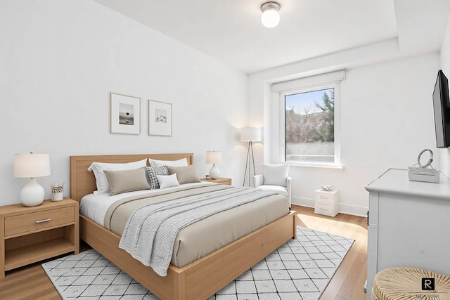 bedroom featuring light wood-style floors and baseboards