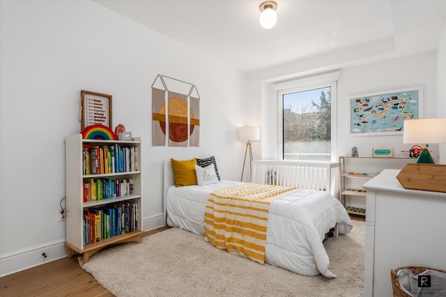 bedroom with wood finished floors and baseboards