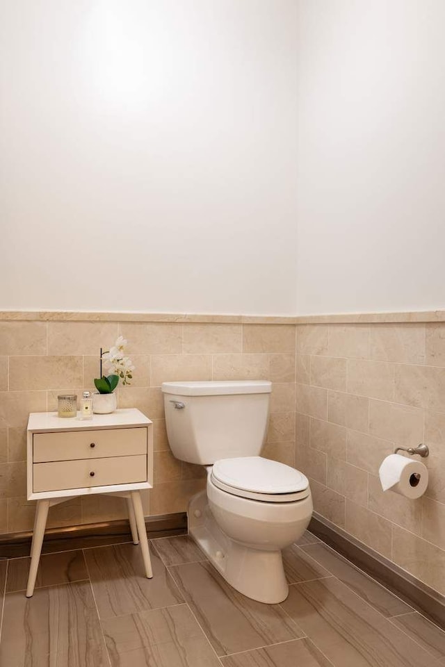 530 Park Ave Unit 5A, New York City, NY 10065 - bathroom featuring tile walls, wainscoting, and toilet