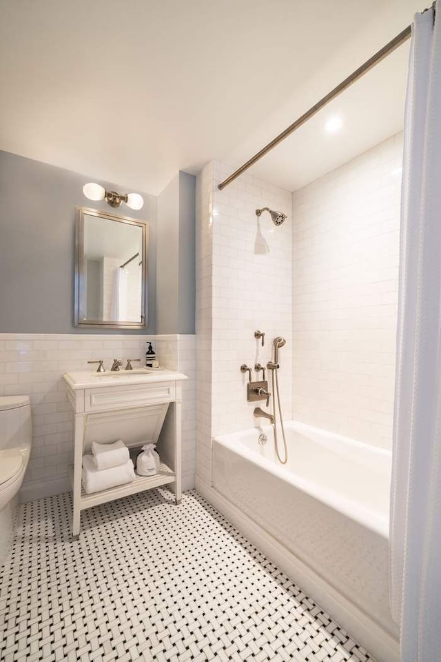 530 Park Ave Unit 5A, New York City, NY 10065 - full bath featuring tile walls, wainscoting, bathtub / shower combination, vanity, and toilet