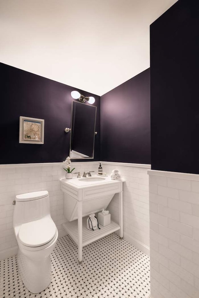 530 Park Ave Unit 5A, New York City, NY 10065 - bathroom featuring tile patterned flooring, wainscoting, toilet, and tile walls