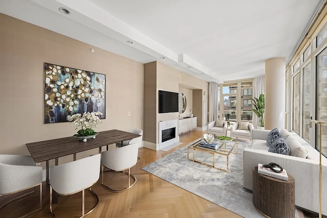 living area featuring recessed lighting, a fireplace with flush hearth, and baseboards