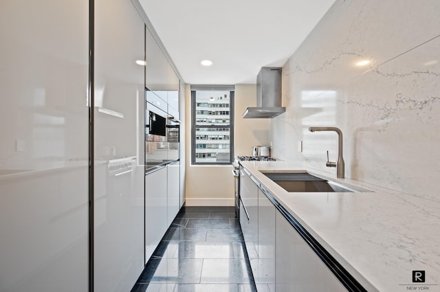 225 E 57th St Unit 18-G, New York City, NY 10022 - kitchen with wall chimney exhaust hood, modern cabinets, gas range, white cabinetry, and light stone counters