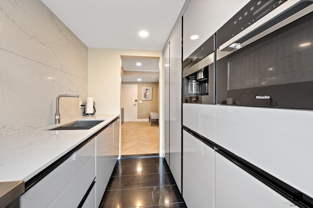 225 E 57th St Unit 18-G, New York City, NY 10022 - kitchen with recessed lighting, white cabinets, modern cabinets, and light stone counters