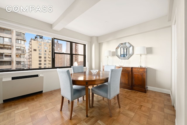 dining space featuring beam ceiling, radiator, and baseboards