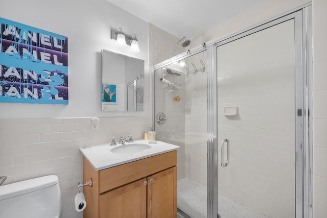69 E 130th St Unit 2A, New York City, NY 10037 - bathroom with tile walls, toilet, vanity, and a shower stall