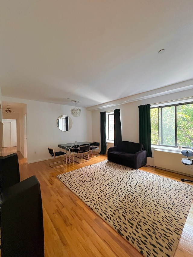 living area featuring light wood finished floors, baseboards, visible vents, and a chandelier