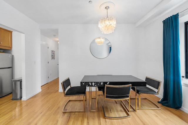 69 E 130th St Unit 2A, New York City, NY 10037 - dining space with light wood finished floors, baseboards, and an inviting chandelier