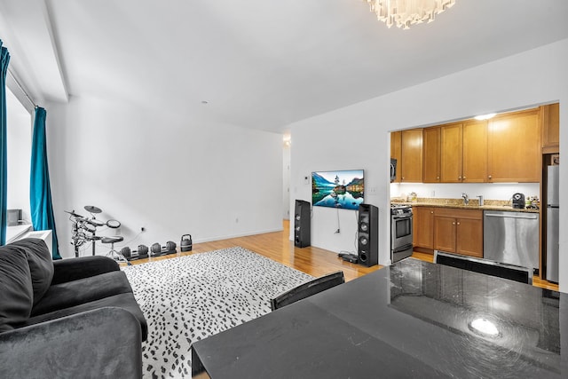 69 E 130th St Unit 2A, New York City, NY 10037 - living room with a notable chandelier and light wood-style floors