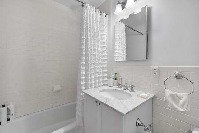 69 E 130th St Unit 2A, New York City, NY 10037 - bathroom featuring vanity, tile walls, and shower / bath combo with shower curtain