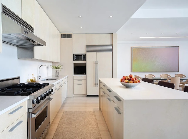 kitchen featuring built in appliances, under cabinet range hood, visible vents, a center island, and modern cabinets