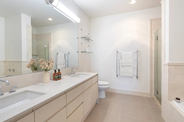 bathroom with a stall shower, a sink, and tile patterned floors