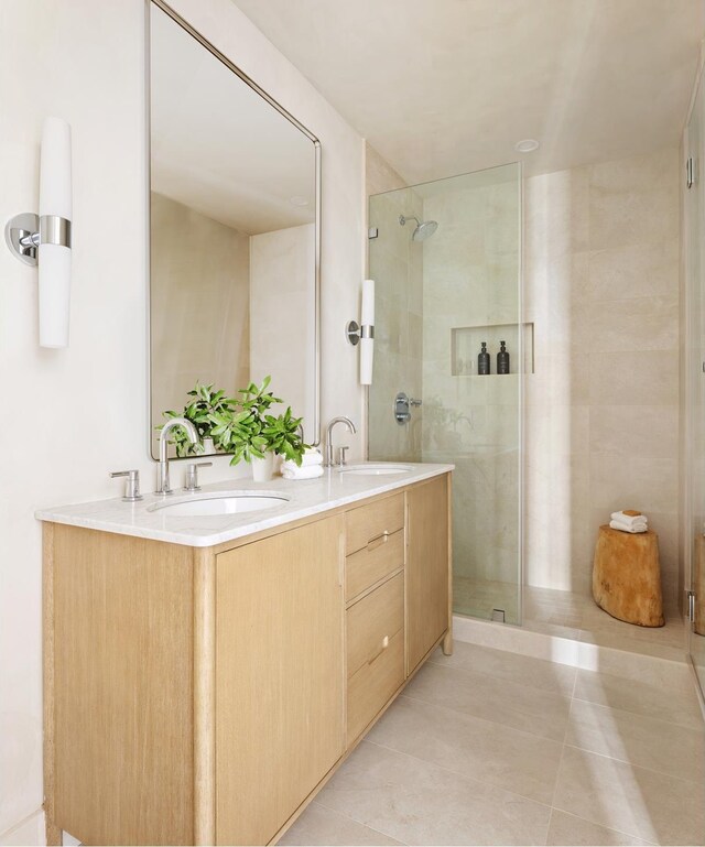 bathroom featuring a sink, tile patterned flooring, and a shower stall