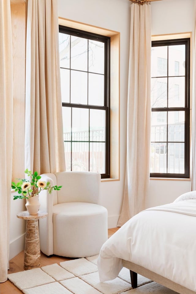 bedroom featuring baseboards, multiple windows, and wood finished floors