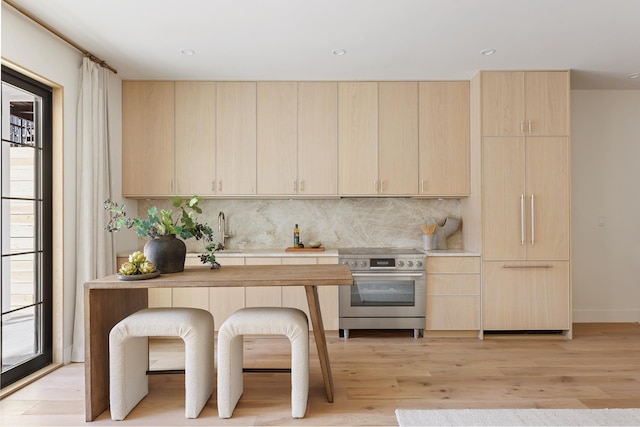 kitchen with light countertops, electric range, light brown cabinets, and light wood finished floors