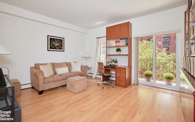 office area with light wood-style flooring and baseboard heating