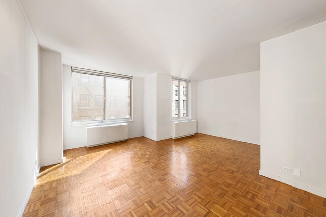 145 E 48th St Unit 8B, New York City, NY 10017 - spare room featuring baseboards and radiator