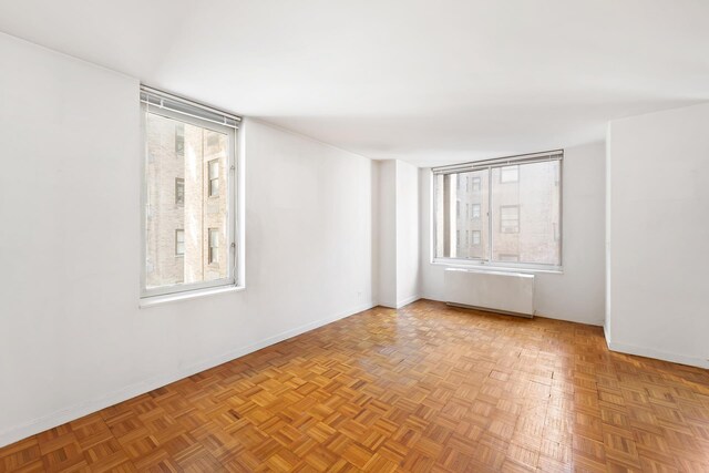 145 E 48th St Unit 8B, New York City, NY 10017 - empty room with baseboards and radiator heating unit