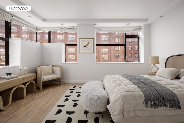 bedroom with wood finished floors and multiple windows