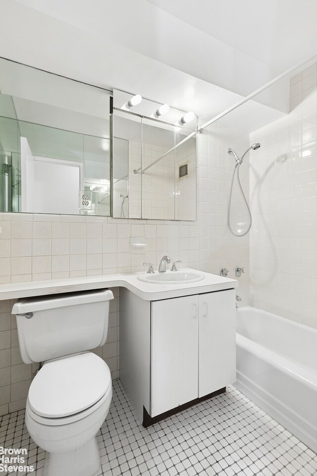 full bathroom featuring toilet, a stall shower, tile walls, and vanity