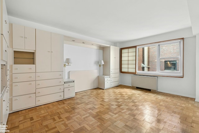 unfurnished room featuring radiator and baseboards