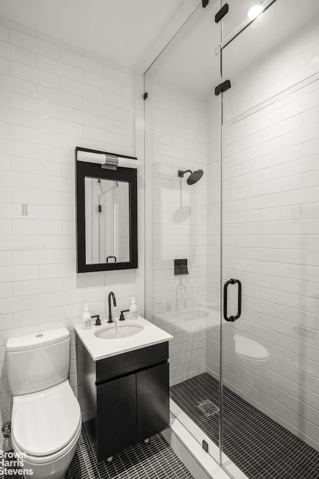 full bath with tile patterned flooring, toilet, vanity, tile walls, and a shower stall