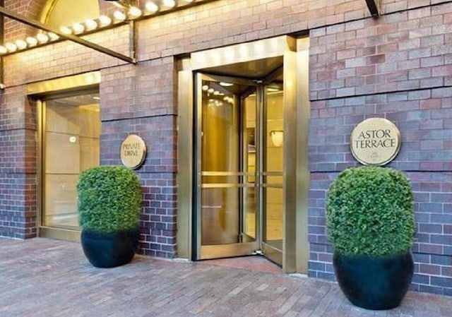 view of exterior entry featuring elevator and brick siding