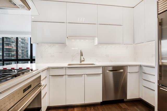 kitchen featuring modern cabinets, a sink, white cabinetry, stainless steel appliances, and light countertops