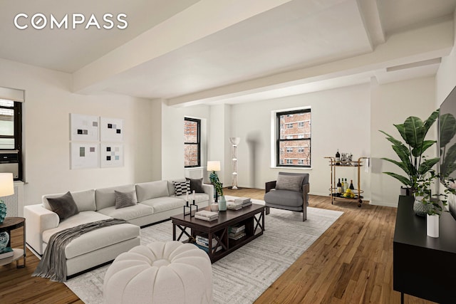 living room featuring beamed ceiling, baseboards, and wood finished floors