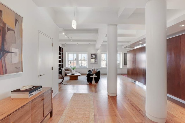 entrance foyer featuring light wood finished floors, beam ceiling, and ornate columns