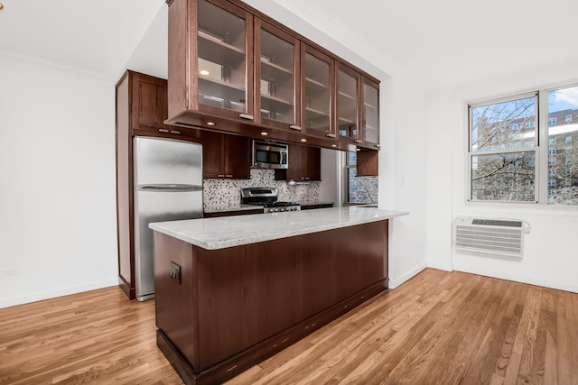 629 Kappock St Unit 4Lm, New York City, NY 10463 - kitchen with stainless steel appliances, a wall mounted air conditioner, light wood finished floors, decorative backsplash, and dark brown cabinetry
