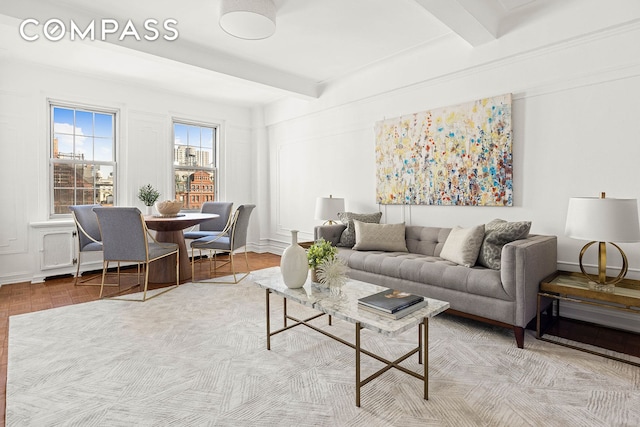 living area featuring beamed ceiling and baseboards