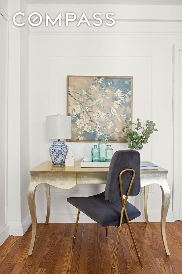 office space with wood finished floors, crown molding, and baseboards