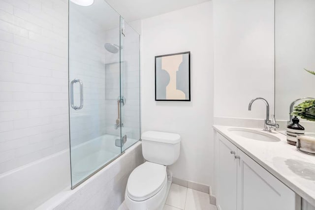 full bath with double vanity, toilet, tile patterned floors, combined bath / shower with glass door, and a sink