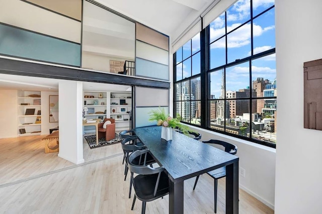 dining room featuring a view of city, built in shelves, and wood finished floors