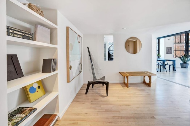 living area featuring light wood-type flooring and baseboards