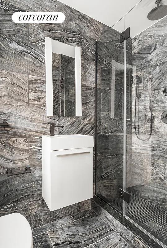 bathroom featuring vanity, a marble finish shower, and toilet