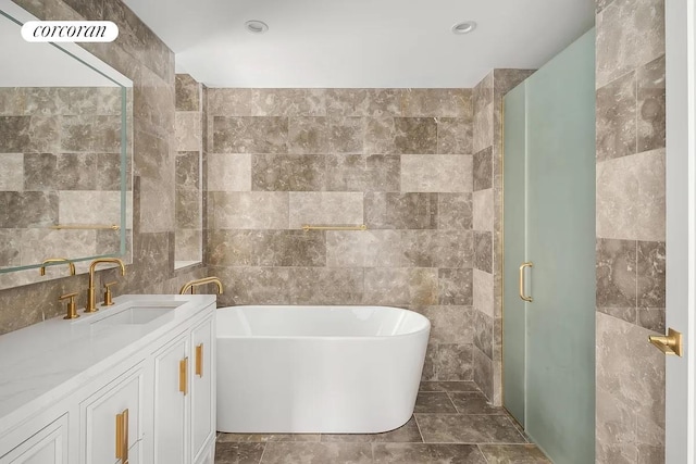 full bath featuring tile walls, a soaking tub, visible vents, a stall shower, and vanity