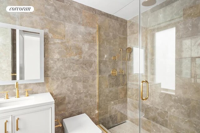 bathroom with visible vents, toilet, vanity, a shower stall, and tile walls