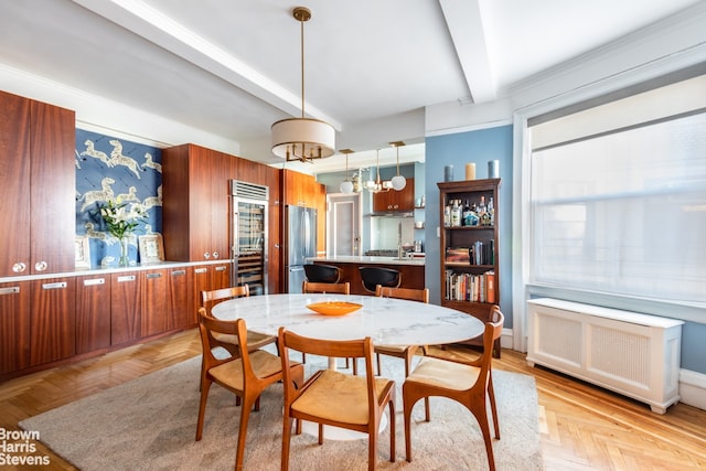 dining area featuring beverage cooler, radiator, beam ceiling, and a chandelier