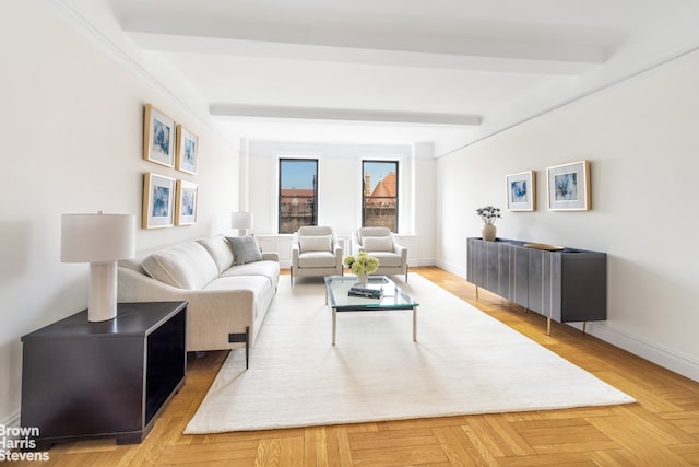 living area featuring beam ceiling and baseboards